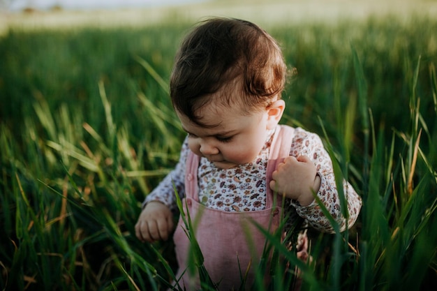 Schöne Baby-Mädchen bei den Pflanzen
