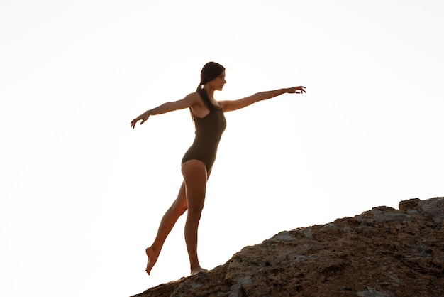 Schöne Ballerina tanzt auf Felsen am Strand Meer Hintergrund posieren