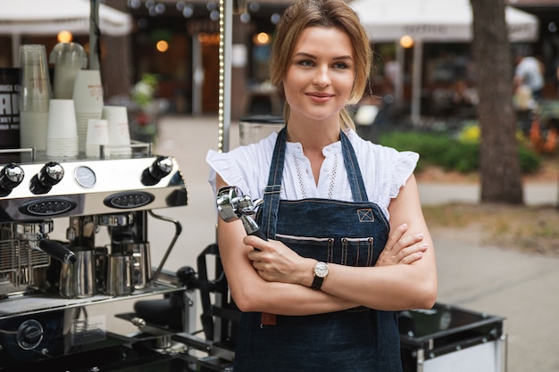 Schöne Barista-Frau während der Arbeit in ihrem beweglichen Straßencafé