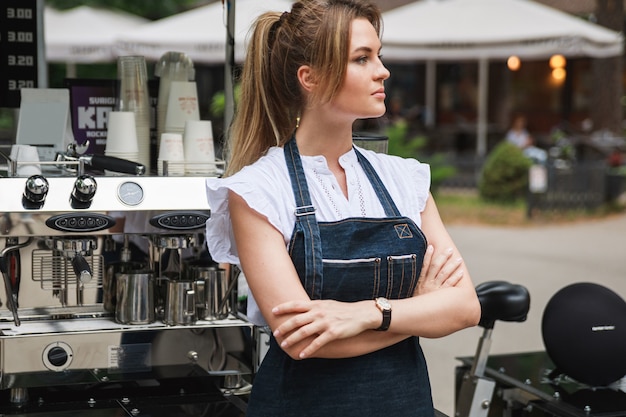 Schöne Barista-Frau während der Arbeit in ihrem beweglichen Straßencafé