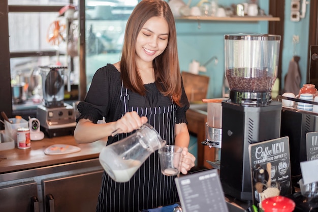 Schöne Barista lächelt in ihrer Kaffeestube