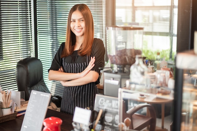 Schöne Barista lächelt in ihrer Kaffeestube