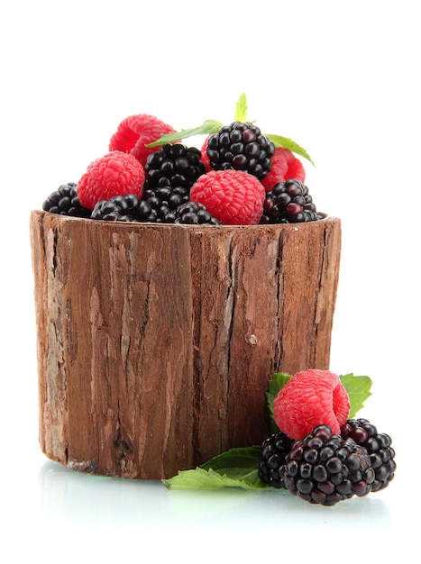 schöne Beeren mit Blättern in einer hölzernen Vase, die auf weiß isoliert ist