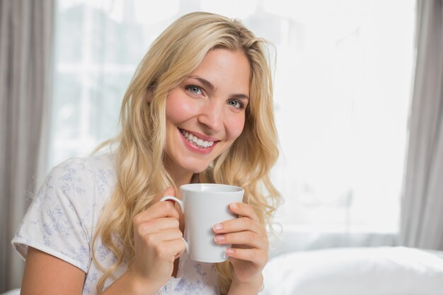 Schöne beiläufige junge Frau, die Kaffeetasse hält