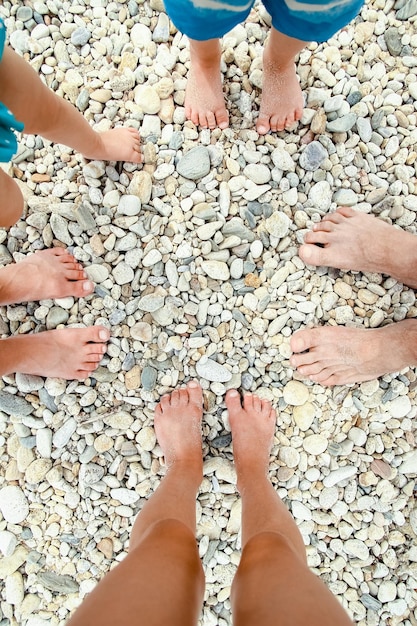 Schöne Beine im Sand des Seegriechenlandhintergrundes