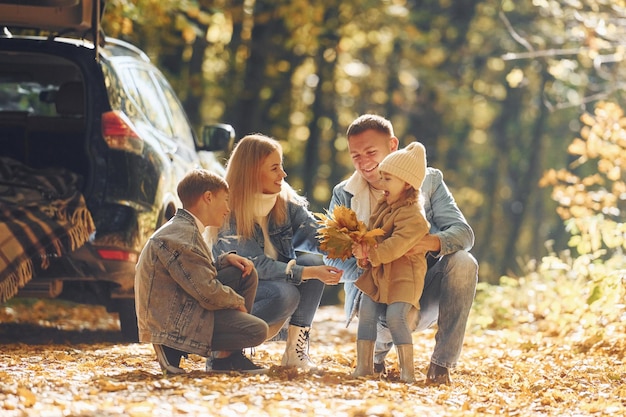 Schöne Blätter Glückliche Familie ist zur Herbstzeit zusammen im Park