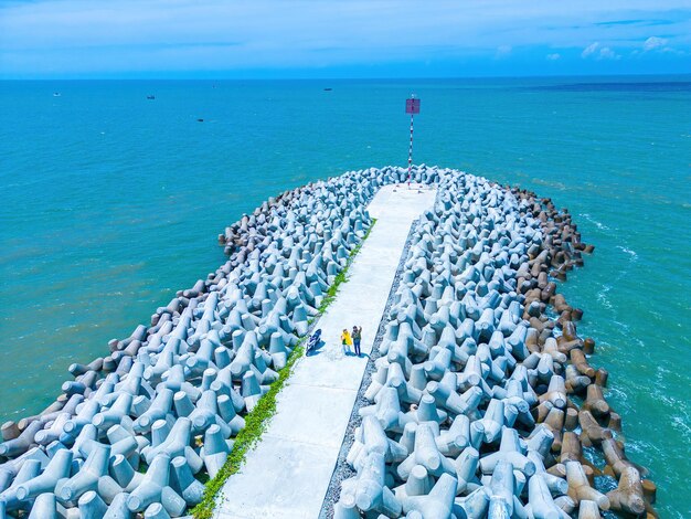 Schöne blaue Skyline Panorama in Loc An Kanal Landschaft Landschaft des Fischereihafens mit Tsunami-Schutz Betonblöcken Stadtbild und Boote im Meer Dorf Loc An in der Nähe von Vung Tau City