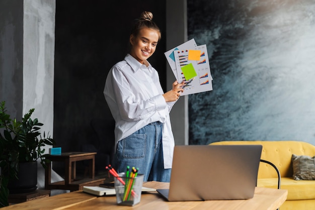 Schöne blonde Beraterin führt Geschäftsanalysen des Unternehmens durch eine Online-Konferenz mit einem Laptop.