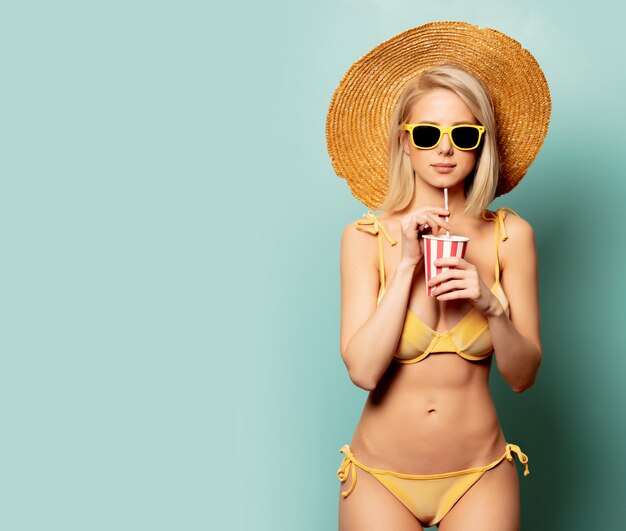 Schöne blonde Frau im Bikini mit Papierschale