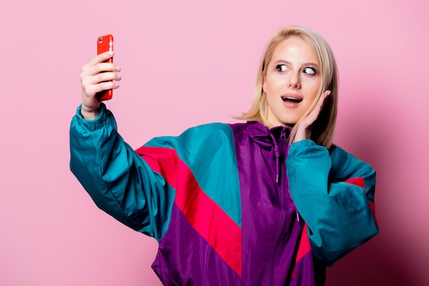 Schöne blonde Frau machen Selfie auf rosa Wand