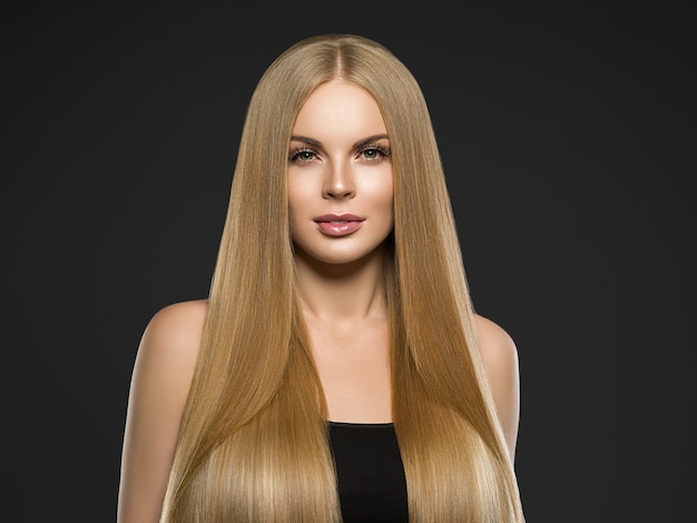 Schöne blonde Frauenfrisur langes glattes gelocktes Haarmodemake-up. Studioaufnahme.