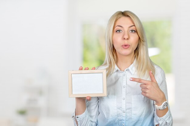 Foto schöne blonde geschäftsfrau, die auf kopienraum zeigt