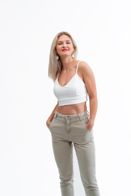 Schöne Blondine in Jeans im Studio auf hellem Hintergrund.