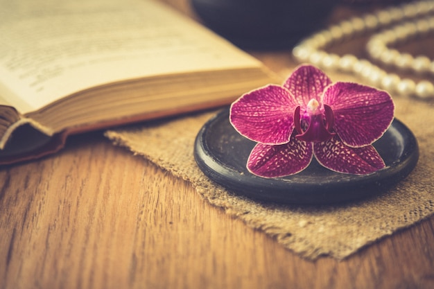 Schöne Blume mit altem Buch und Tasse Kaffee oder Tee. Romantischer Hintergrund mit Retro-Filtereffekt