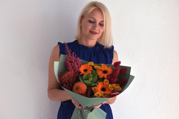 Schöne Blumen für den Urlaub Frau mit schönen Blumen in den Händen drinnen Hintergrund Blumenstrauß für Blumenladen