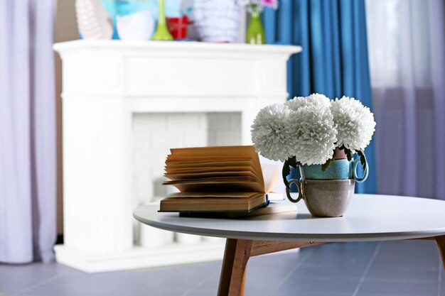 Schöne Blumen in der Vase auf Tisch im Zimmer