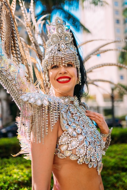 Schöne Brasilianerin, die bunte Karnevalskostüme trägt und während der Carnaval Street Parade in der Stadt lächelt.