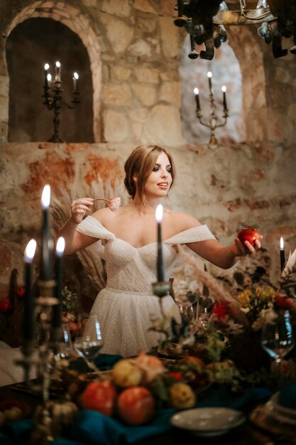 Foto schöne braut am hochzeitstisch, reich dekoriert im rustikalen stil