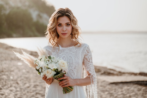 Schöne Braut, die ihre Hochzeit am Strand hat