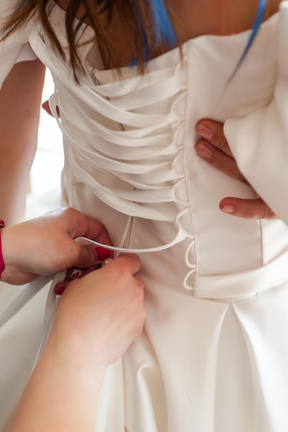 Schöne Braut, die im Hochzeitskleid in einem weißen Fotostudio aufwirft