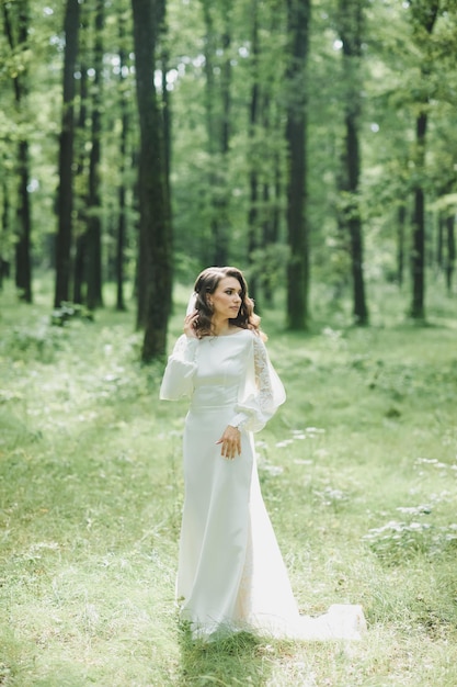 Schöne Braut im Modehochzeitskleid auf natürlichem Hintergrund.