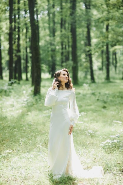 Schöne Braut im Modehochzeitskleid auf natürlichem Hintergrund.