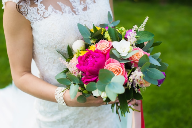 Schöne Braut im weißen Spitzenkleid mit Armband