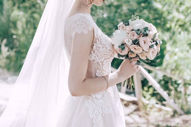 Schöne Braut mit einem Blumenstrauß in Pastellfarben