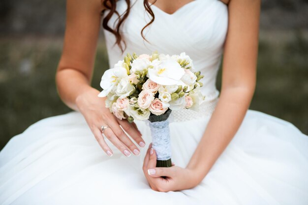 Schöne Braut mit Hochzeitsblumenstrauß attraktive Frau im Hochzeitskleid Glückliches Jungvermählten