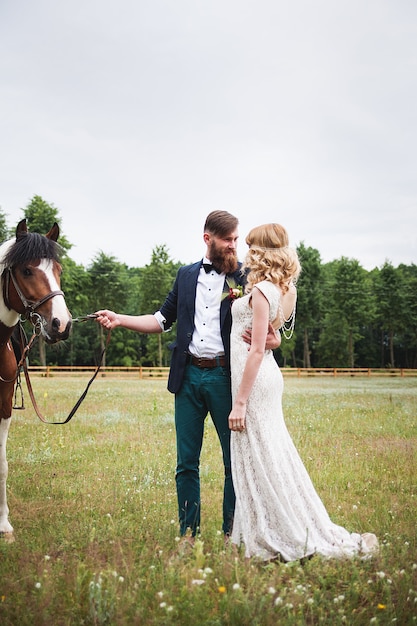 Schöne Braut und Bräutigam Hipster stehen neben dem Pferd, rustikalen Stil