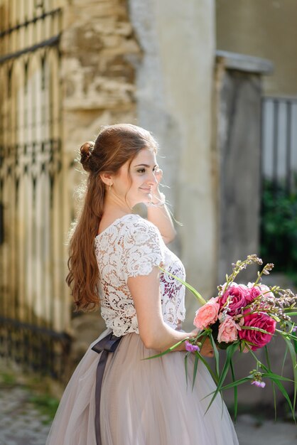 Schöne Brautporträthochzeits-Make-up-Frisur, wunderschöne junge Frau im weißen Kleid zu Hause. Serie.