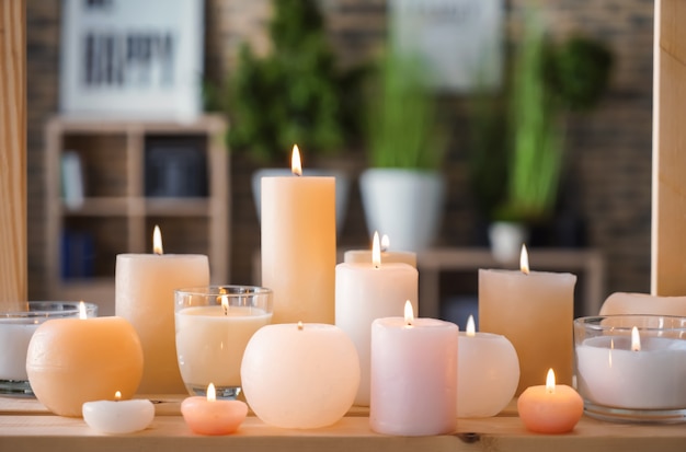 Schöne brennende Kerzen auf Holztisch drinnen