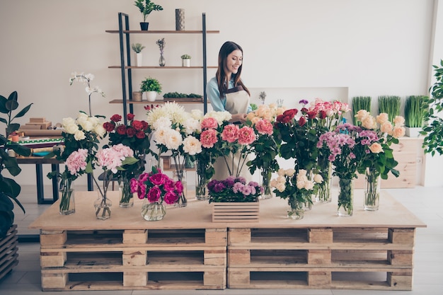 schöne brünette Botanikerin, die in ihrem Blumenladen aufwirft