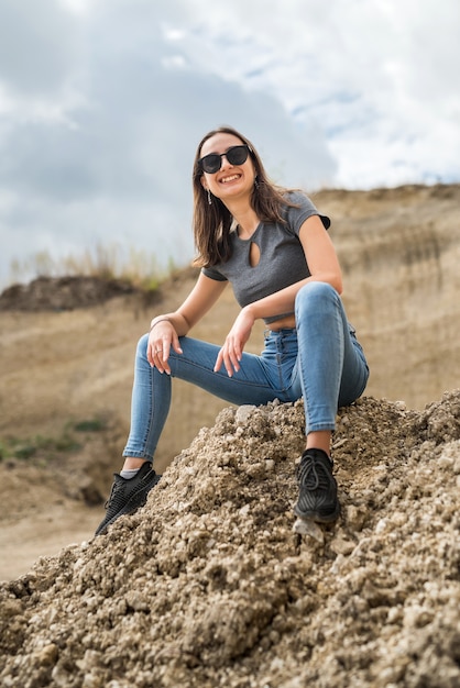 Schöne brünette Dame im Sandsteinbruch entspannen und genießen Sie ihre Zeit an einem sonnigen Sommertag