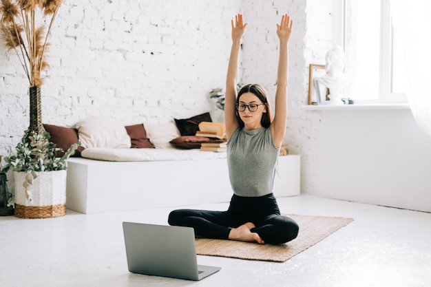 Schöne brünette Fitnessfrau machen Dehnübungen