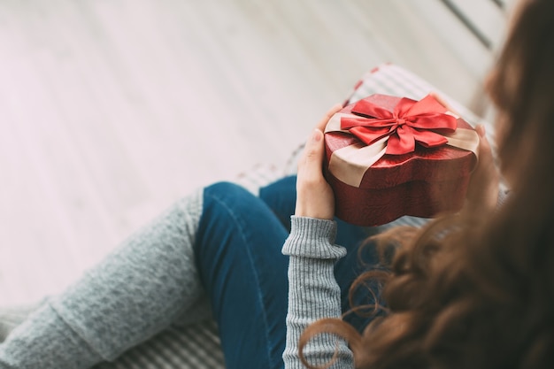 Schöne brünette Frau, die eine Geschenkbox hält