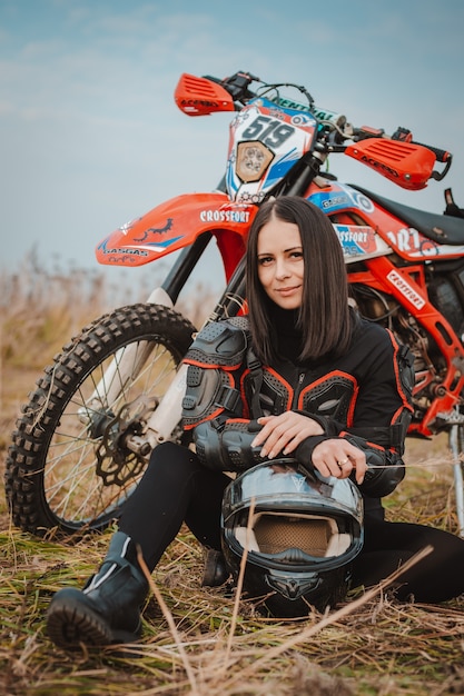 Schöne brünette Frau im Motorradoutfit.