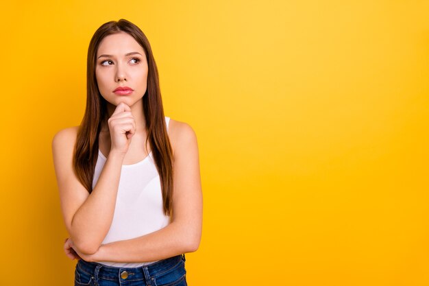 Schöne brünette Frau mit den roten Lippen, die gegen die gelbe Wand aufwerfen