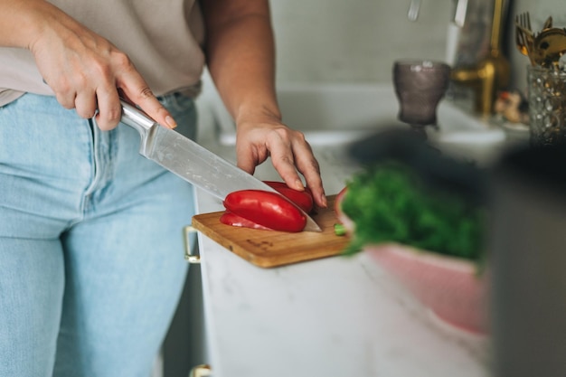 Schöne brünette junge Frau plus körperpositiver Kochsalat in der Küche zu Hause