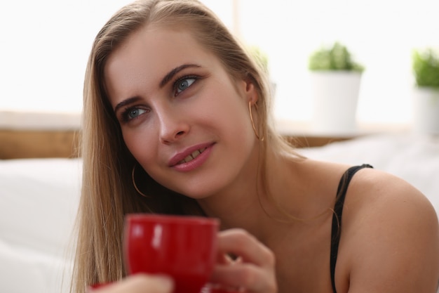 Schöne Dame, die am frühen Morgen eine Tasse Kaffee trinkt