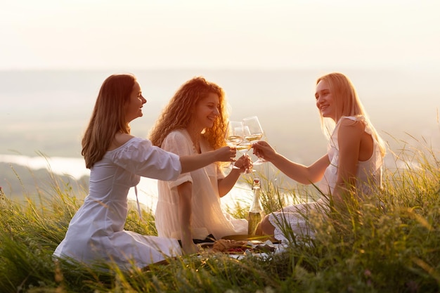 Foto schöne damen trinken wein bei sonnenuntergang