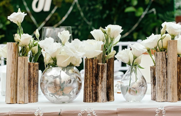 Schöne dekoration bei der hochzeit die blumen auf dem hintergrund der tafeln closeup