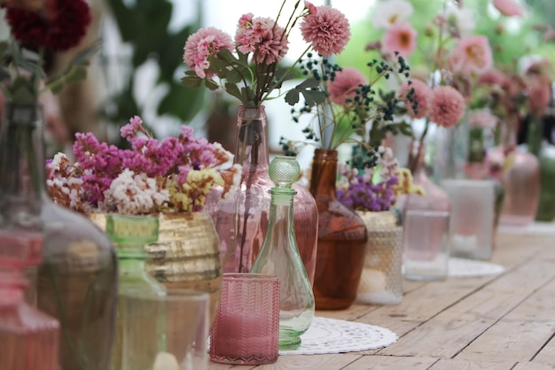 Schöne Dekoration mit Blumen und bunten Glasvasen