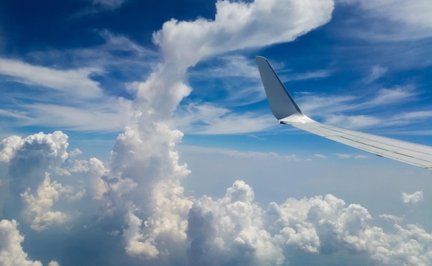 Schöne dicke Wolken am Himmel aus der Flughöhe des Flugzeugs mit Blick auf den Flügel mit Triebwerken