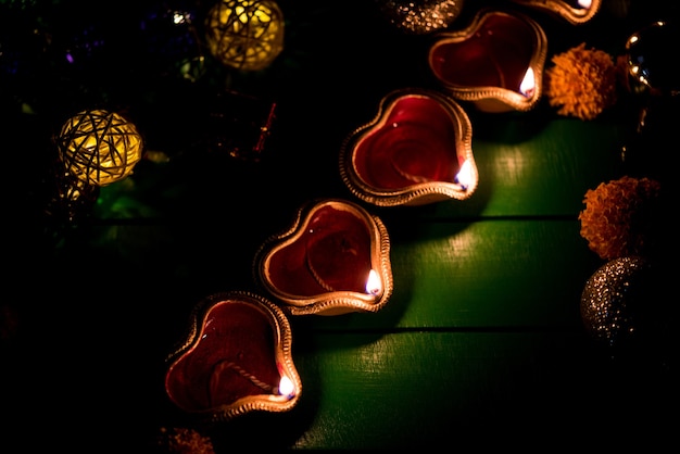 Schöne Diwali Diyas in der Nacht mit Blumen, Beleuchtungsserien und Geschenken, stimmungsvolle Szene