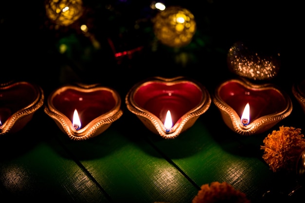 Schöne Diwali Diyas in der Nacht mit Blumen, Beleuchtungsserien und Geschenken, stimmungsvolle Szene