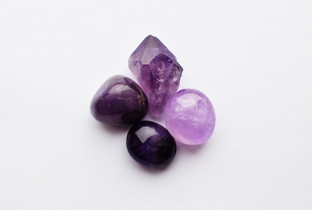 Schöne Edelsteine aus natürlichem lila Mineral Amethyst auf weißem Hintergrund. Große Kristalle aus Halbedelsteinen.