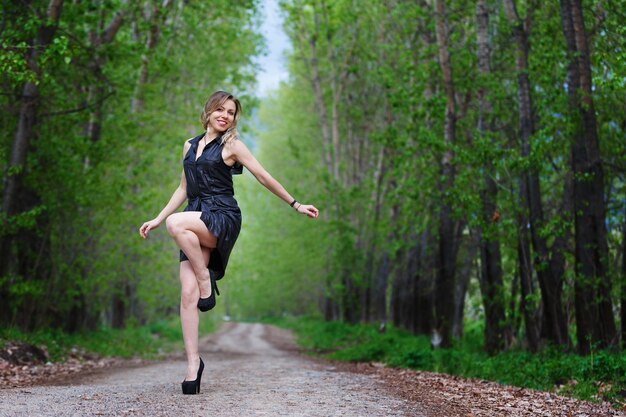 Schöne elegante Frau, die auf einer Landstraße geht