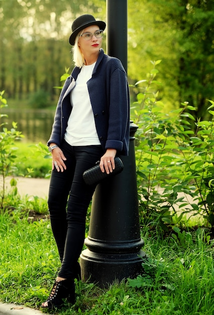 Schöne elegante Frau, die im Herbst in einem Park steht