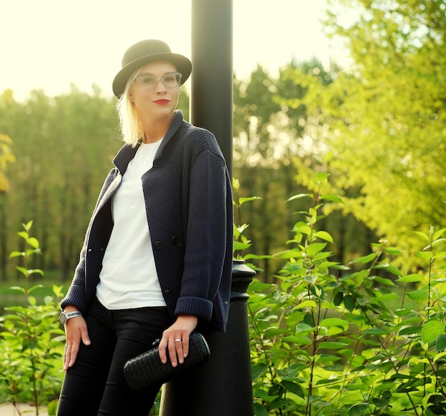 Schöne elegante Frau, die in einem Park im Herbst steht